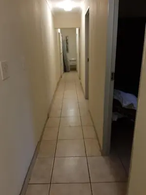 a hallway with a tiled floor in a room at Roullas gardens in Pretoria