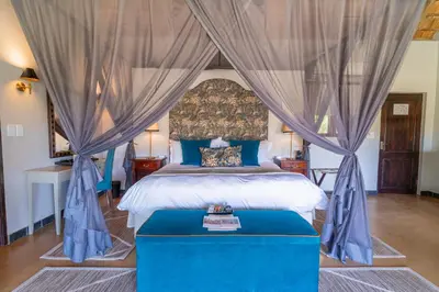 a bedroom with a blue bed with a canopy at Last Word Kitara in Klaserie Private Nature Reserve