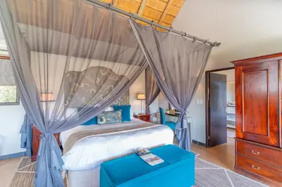a bedroom with a canopy bed and a wooden dresser at Last Word Kitara in Klaserie Private Nature Reserve