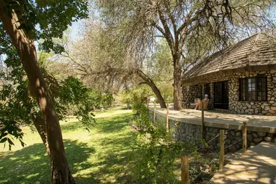 a person sitting in front of a stone house at Last Word Kitara in Klaserie Private Nature Reserve