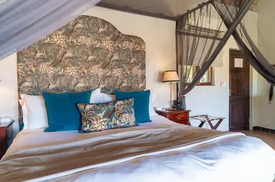 a bedroom with a large bed with a large headboard at Last Word Kitara in Klaserie Private Nature Reserve