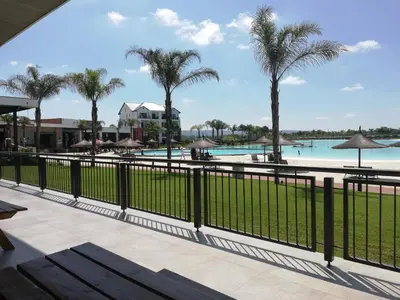 a view of the pool at a resort with palm trees at The Blyde Riverwalk Estate in Pretoria