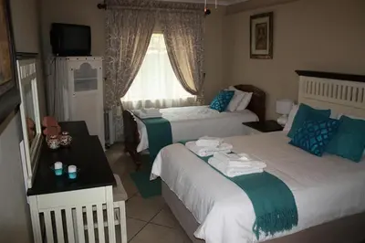 a hotel room with two beds and a window at Big Tree Guesthouse Brits in Brits