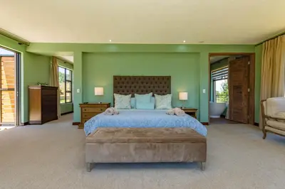 a bedroom with a large bed and green walls at 93 Hillcrest in Dullstroom