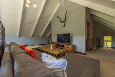 a living room with a couch and a tv at 93 Hillcrest in Dullstroom