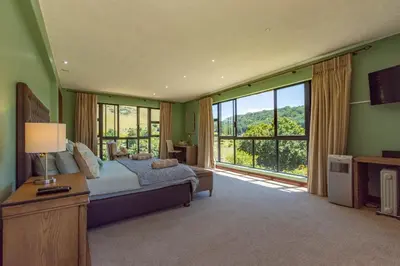 a bedroom with a bed and a large window at 93 Hillcrest in Dullstroom
