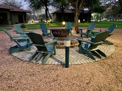 a group of chairs and a table in a park at Rip van Winkel Guest House in Lephalale