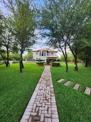 a brick path in front of a house with trees at Rip van Winkel Guest House in Lephalale