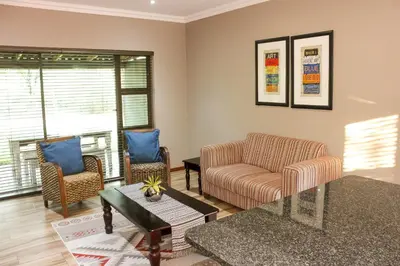 a living room with a couch and two chairs at Rip van Winkel Guest House in Lephalale