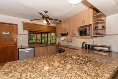a kitchen with a granite counter top and a ceiling fan at Kruger Park Lodge Unit No 441 with Private Pool in Hazyview