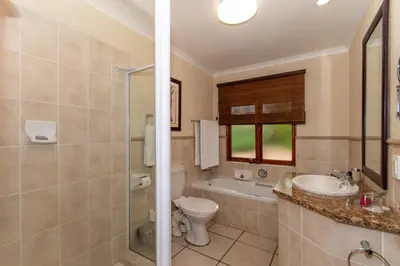 a bathroom with a toilet and a sink and a shower at Kruger Park Lodge Unit No 441 with Private Pool in Hazyview