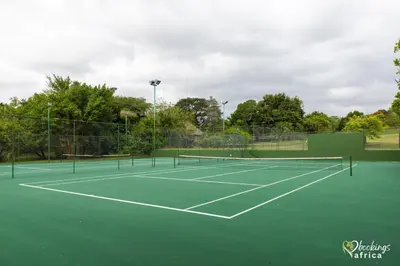 a tennis court with two tennis rackets on it at Kruger Park Lodge Unit No 441 with Private Pool in Hazyview