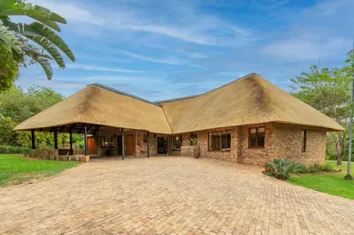 a large brick building with a thatched roof at Kruger Park Lodge Unit No 441 with Private Pool in Hazyview