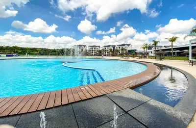a large swimming pool with a wooden deck and water fountain at The Blyde River Walk Estate in Pretoria