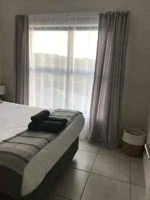 a bed in a room with a large window at The Blyde River Walk Estate in Pretoria