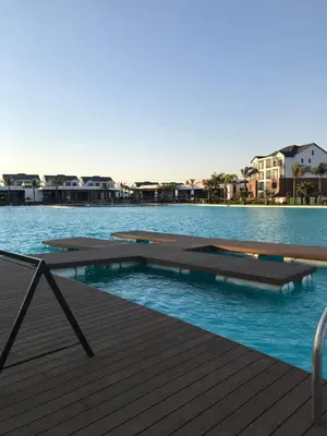 a swimming pool with a wooden deck and water at The Blyde River Walk Estate in Pretoria