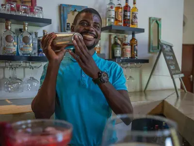 a man is smiling while holding a bar at The Wild Blue Lodge SAFARI & SPA in Hoedspruit