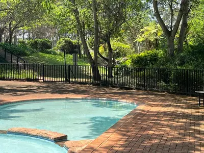 a small swimming pool in a park with a fence at Thyme Inn on Greenway in White River