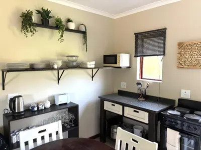 a kitchen with a counter and a table and a microwave at Thyme Inn on Greenway in White River