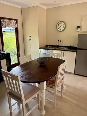 a kitchen with a table and chairs and a clock on the wall at Thyme Inn on Greenway in White River