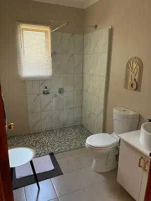 a bathroom with a shower and a toilet at Thyme Inn on Greenway in White River