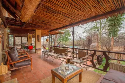an open living room with chairs and a table at Lovely holiday home bordering Kruger National Park in Marloth Park