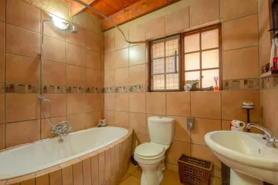 a bathroom with a tub and a toilet and a sink at Lovely holiday home bordering Kruger National Park in Marloth Park