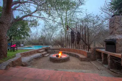 a fire pit in a yard next to a pool at Lovely holiday home bordering Kruger National Park in Marloth Park