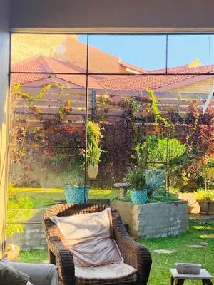 a wicker chair with a pillow on a patio at Douglas Villas in Tzaneen