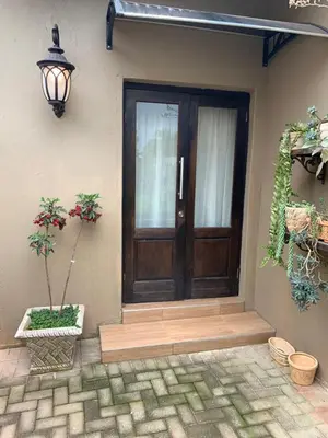 a wooden door of a house with a potted plant at Douglas Villas in Tzaneen