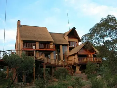 a large wooden house with a large deck at Ngong Hill, Mabalingwe in Bela-Bela