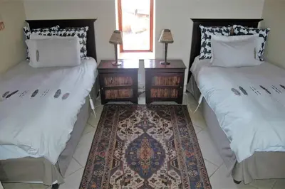a room with two beds and a rug at Ngong Hill, Mabalingwe in Bela-Bela