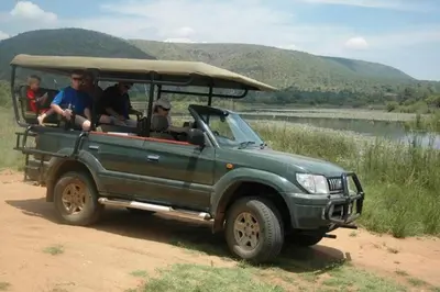 a group of people riding in a green jeep at Ngong Hill, Mabalingwe in Bela-Bela