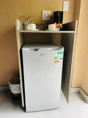 a small white refrigerator in a kitchen with a counter at Pan African Lodge & Safari in Marloth Park