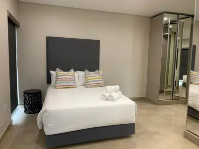 a bedroom with a large white bed with two pillows at 77 On Burger in Polokwane