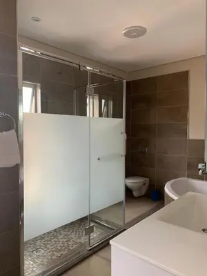 a bathroom with a glass shower with a toilet at 77 On Burger in Polokwane