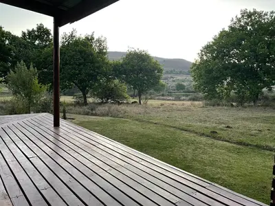 a wooden deck with a view of a field at Walkersons Trout and Nature Haven in Dullstroom