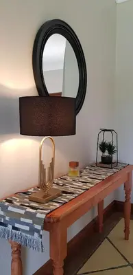 a mirror on top of a table with a lamp at Walkersons Trout and Nature Haven in Dullstroom
