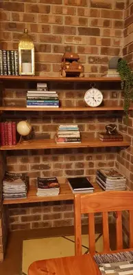 a brick wall with a desk and a clock at Walkersons Trout and Nature Haven in Dullstroom