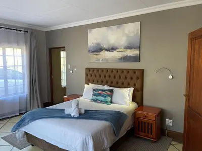 a bedroom with a bed and a painting on the wall at Walkersons Trout and Nature Haven in Dullstroom
