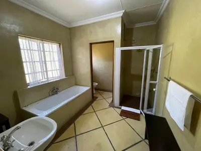 a bathroom with a bath tub and a sink at Walkersons Trout and Nature Haven in Dullstroom