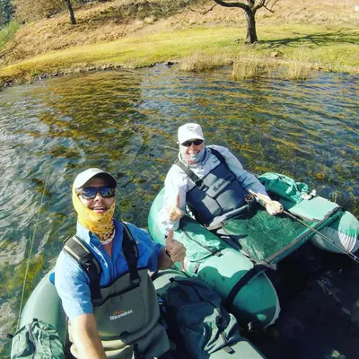 two people are sitting in kayaks on a river at Walkersons Trout and Nature Haven in Dullstroom