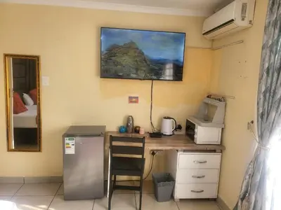 a kitchen with a counter with a refrigerator and a microwave at Hadassa Lodge in Burgersfort