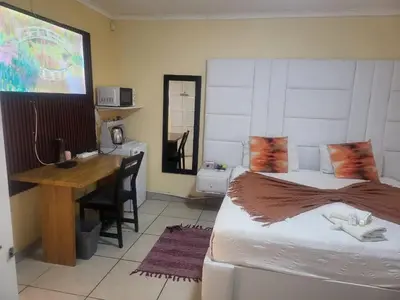 a bedroom with a desk and a bed and a desk and a desk at Hadassa Lodge in Burgersfort