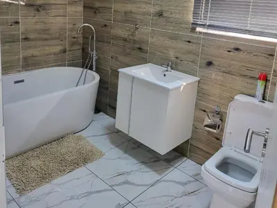 a bathroom with a toilet and a tub and a sink at Hadassa Lodge in Burgersfort