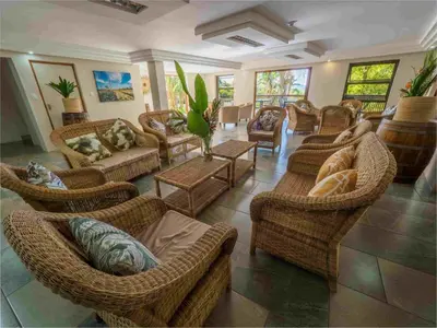 a living room with wicker chairs and couches at Umbhaba Eco Lodge in Hazyview