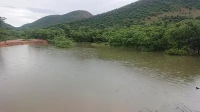 a body of water with mountains in the background at Cross Pollination Chalets & Camping in Vaalwater