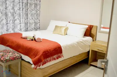 a bedroom with a bed with a red blanket at The Blyde - Posh Living in Pretoria