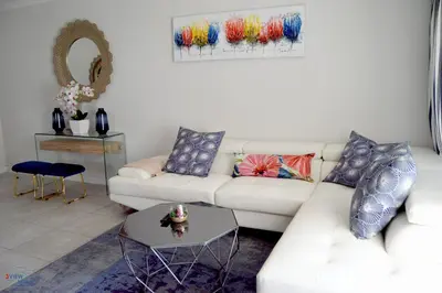 a living room with a white couch and a table at The Blyde - Posh Living in Pretoria