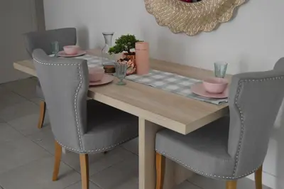 a dining room table with two chairs and a wooden table at The Blyde - Posh Living in Pretoria